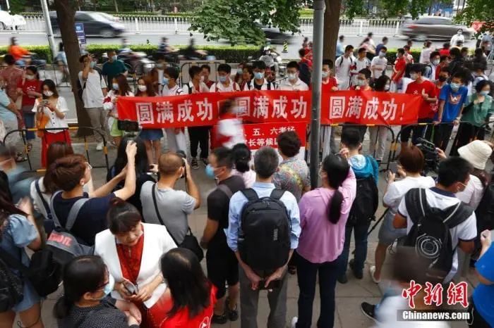 6月7日，北京人大附中考点外，送考同学为考生拉横幅加油。中新社记者 富田 摄